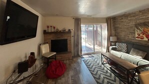 A living room with a fireplace, a television mounted on the wall, a sofa, and a coffee table. - Heavenly Hideaway in Ski Run | Deck | BBQ (South Lake Tahoe)