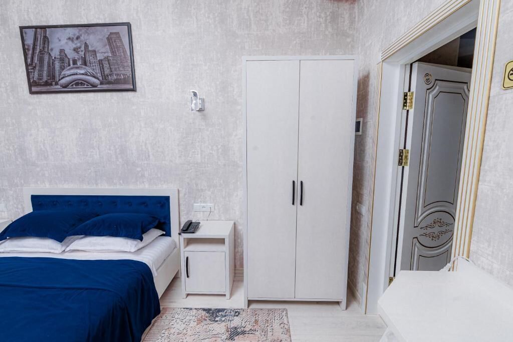 Un dormitorio con cama, armario, mesita de noche y una puerta.