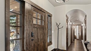 A hallway with a wooden door, a coat rack, and a bench. - 2,500 Sq Ft Cabin | 2 Living Rooms | BBQ (South Lake Tahoe)