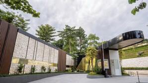 A modern building with a stone facade and a curved entrance. - Royal Urban Resort (Caringin)