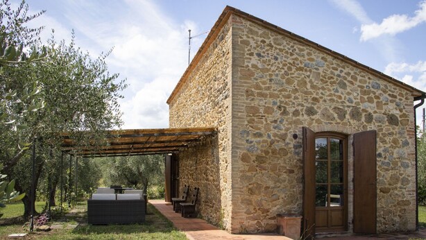 A stone building with a wooden door and a pergola. - Cosy apartment with pool, A/C, WIFI, TV, patio and panoramic view, close to San Gimignano (Montauto)