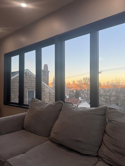 Downtown skyline vista featuring giant rooftop deck & wet bar with a city view