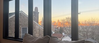 Downtown skyline vista featuring giant rooftop deck & wet bar with a city view