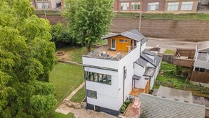 Una casa moderna de dos pisos con techo plano y un pequeño garaje adosado.