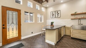 Una cocina moderna con una isla central, armarios de madera y un suelo con patrón de espiga.