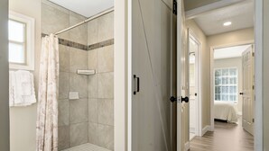 A shower with a beige curtain, a tiled shower area, and a white towel rack. - Vacation Home in Lady Lake (Lady Lake)