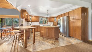 Una cocina moderna con armarios de madera, una isla central y un refrigerador de acero inoxidable.
