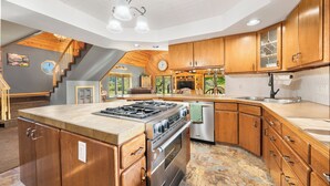 Una cocina amplia con armarios de madera, una isla grande y un horno empotrado.