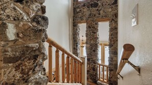 Una escalera de piedra con barandillas de madera que conduce a un nivel superior.
