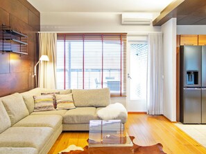 A modern living room with a sectional sofa, a glass coffee table, and a refrigerator. - Tahko spa suites white b 7 by Interhome (Nilsiä)