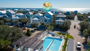 Un resort con varias edificaciones, una piscina y vista al océano.