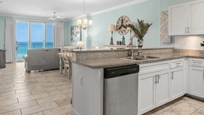A spacious kitchen with a central island, white cabinetry, and a view to the outside.