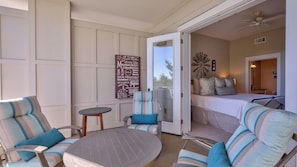 A room with a bed, a round table, and two chairs.