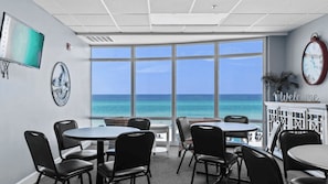 A conference room with large windows, a clock, and a welcome sign. - Front Beach Road, Unit 809 - Beach Happy Emerald Isle Resort Unit 809 (Panama City Beach)