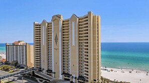 A high-rise hotel with multiple balconies, a beach view, and a clear sky. - Front Beach Road, Unit 809 - Beach Happy Emerald Isle Resort Unit 809 (Panama City Beach)