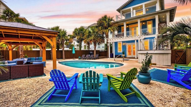 A pool area with lounge chairs, a covered seating area, and a building with a balcony. - 5min Walk to Beach Private Pool, Rooftop Deck A Piece of Heaven by Avantstay (Santa Rosa Beach)