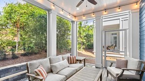 A covered outdoor seating area with a sofa, chairs, and a table. - Cabana Blue by Avantstay Walk to Beach, Golf Cart+bikes Included Pool Access (Santa Rosa Beach)