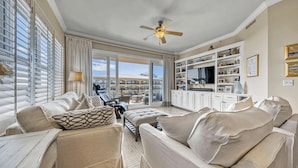 Ein Wohnzimmer mit Sofa, Hocker und Deckenventilator.