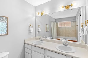 A modern bathroom with two sinks, a large mirror, and a shower visible in the reflection. - Bayou Bungalow by Avantstay Walk to Boat Ramp & Bay Private Yard (Santa Rosa Beach)