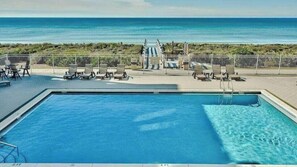 A pool with a view of the ocean, lounge chairs, and a fenced area. - Steps to Rosemary Beach, Pool, Patio w/ Firepit The Salty Perch by Avantstay (Panama City Beach)