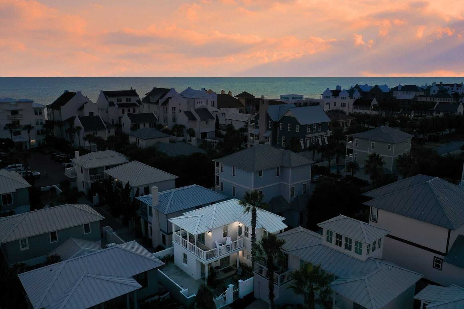A coastal residential area with houses featuring balconies and a view of the ocean.