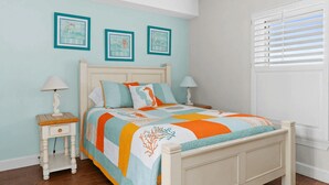 A bedroom with a bed, two bedside tables, and a window with blinds. - Emerald Isle Resort 405 by Avantstay Beachfront, Beach Chairs + Pool Access (Panama City Beach)
