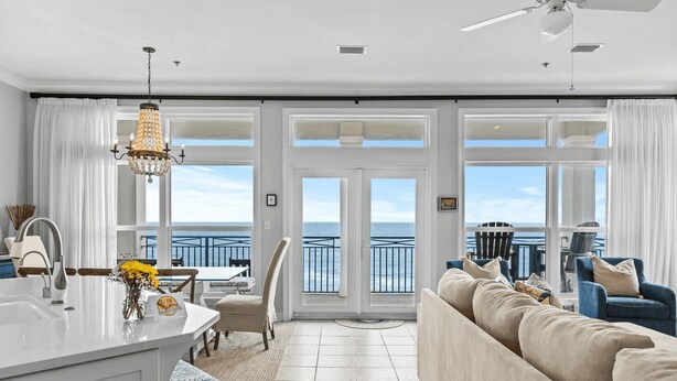 Un vaste espace de vie comprenant un grand canapé, une table à manger et un îlot de cuisine.
