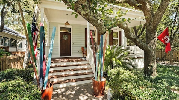 A house with a porch, steps leading to the door, and a tree in the foreground.