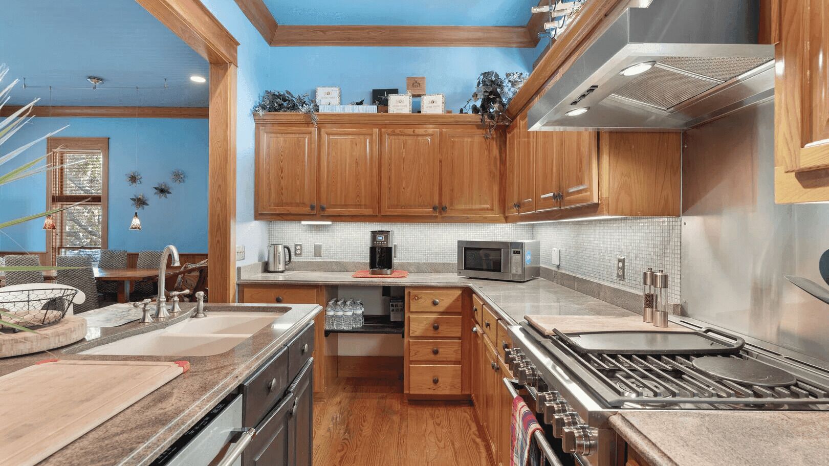 A kitchen with wooden cabinets, a stainless steel range, a microwave, and a coffee maker.