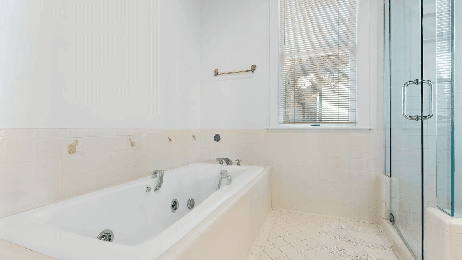 Une salle de bain moderne avec une baignoire sur pieds, une douche en verre et une fenêtre avec des stores.