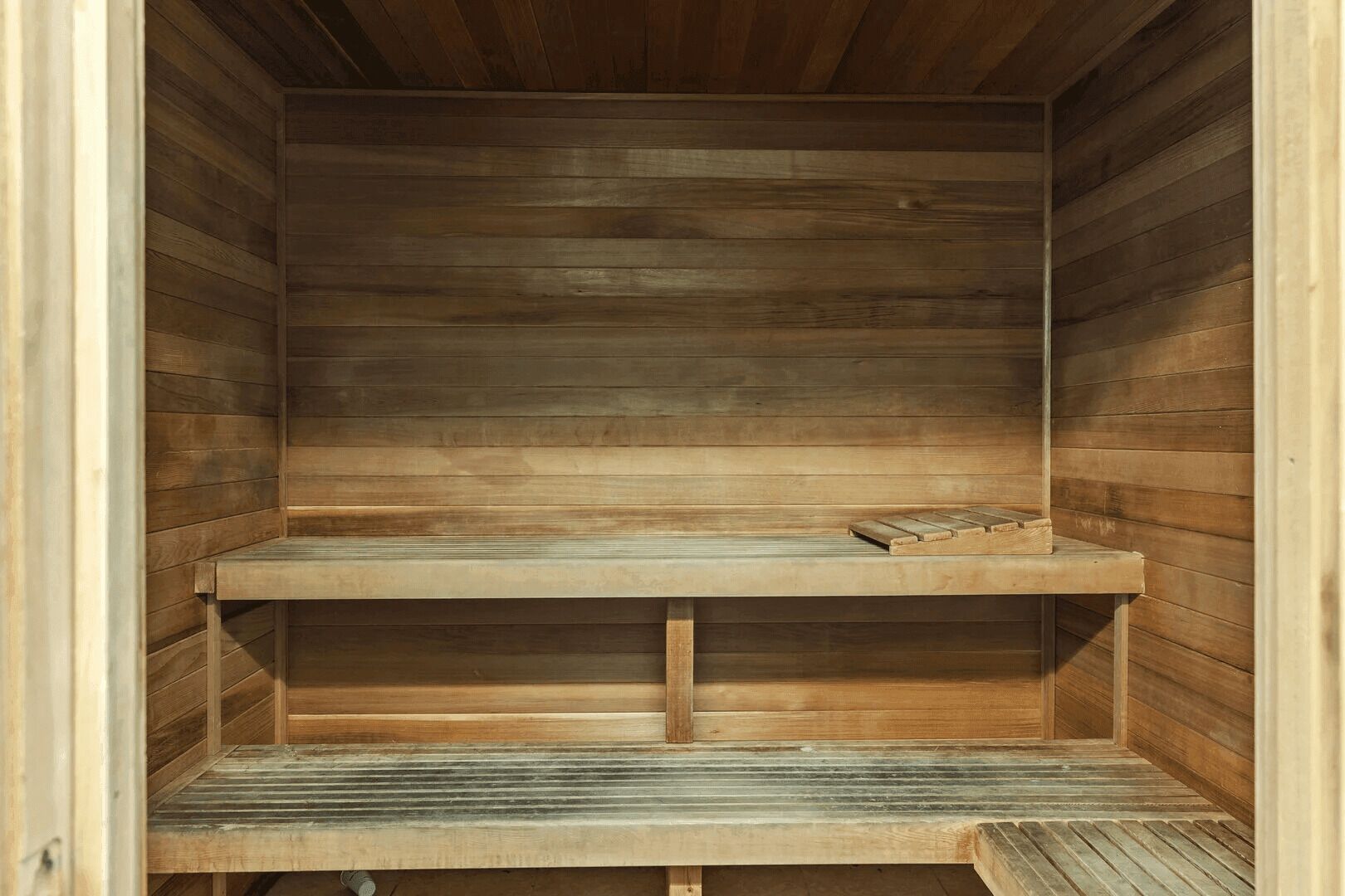 Una sauna de madera con un banco y un estante.