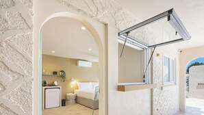 A hotel room with a bed, a desk, a chair, a small kitchenette, and a bathroom. - The Shores Miami (Miami)