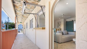 A corridor with a ceiling mural, a reception desk, a sofa, and a view of the outside. - The Shores Miami (Miami)