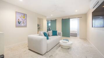 A modern living room with a sofa, a coffee table, and a painting on the wall.
