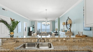 A kitchen with granite countertops, stainless steel sinks, and white cabinetry. - Beachfront Access, 2 Pools, Beach Service w/ Chairs Emerald Isle Resort 1308 (Panama City Beach)