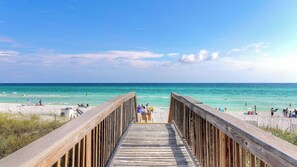 A wooden boardwalk leading to a beach with clear turquoise water and a sandy shore. - Holiday House by Avantstay Oceanview, Steps to Beach (Santa Rosa Beach)