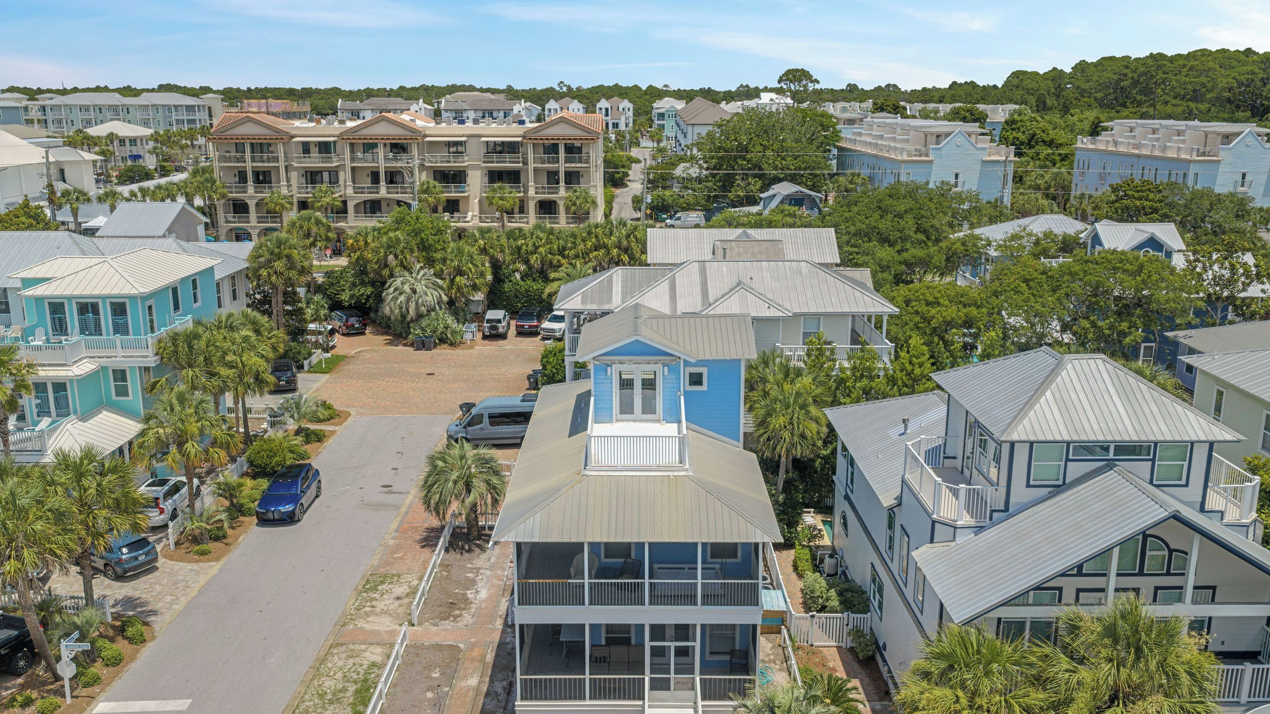 A residential area with multiple two-story houses, a central parking area, and surrounding greenery.