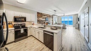 A modern kitchen with white cabinets, a wooden backsplash, and a large island.