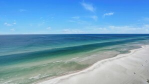 A beach with clear blue water and a sandy shore.
