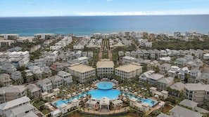 A resort with a central pool, multiple buildings, and a view of the ocean. - Southern Shores by Avantstay Seacrest Beach Resort Pool (Panama City Beach)
