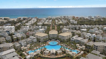 Un resort con piscina central, varias construcciones y vista al océano.
