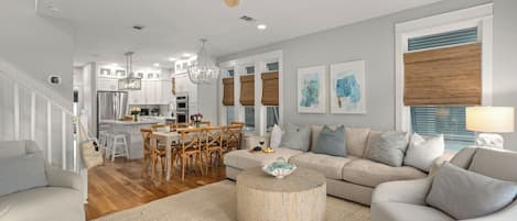 A modern living room with a sofa, coffee table, and dining area.