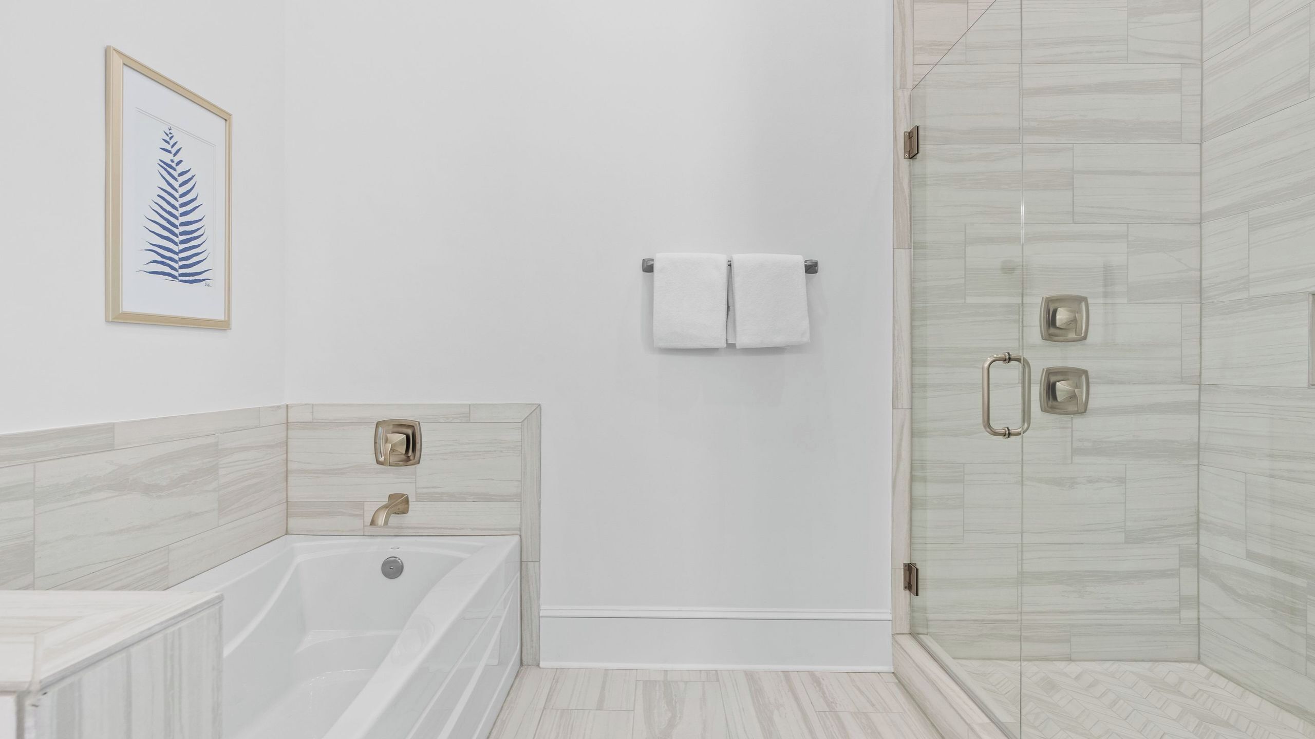 Ein modernes Badezimmer mit einer Badewanne, einer Dusche und einem Duschbereich mit Glaswand.