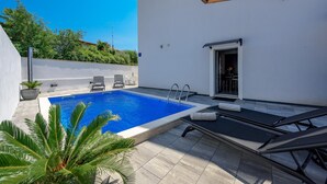 A rooftop pool area with a clear blue pool, lounge chairs, and a door leading to an indoor space. - Apartment in Kukci With Heated Pool (Porec)