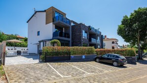 Un moderno edificio residenziale a più piani con un'area di parcheggio antistante.