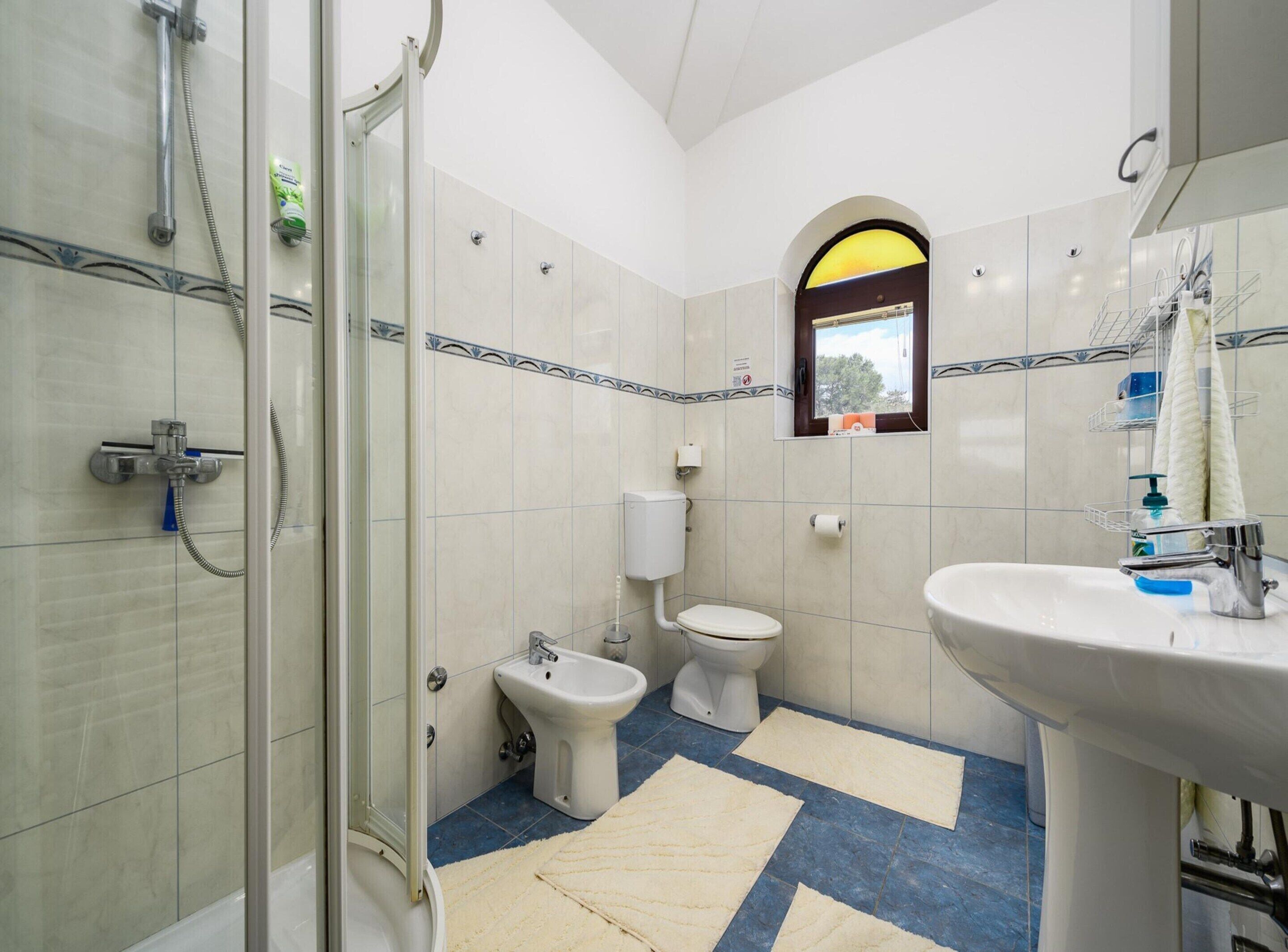 Ein Badezimmer mit Dusche, Toilette, Bidet und Waschbecken.