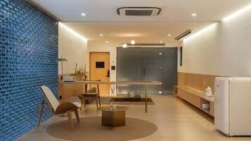 A modern kitchen with a dining area, featuring a round table, chairs, and a refrigerator.