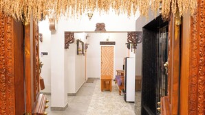 Un corridoio con porte in legno decorate e una porta centrale con motivo geometrico.