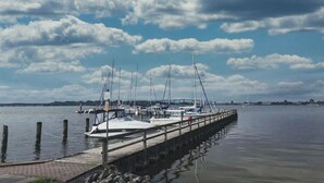 A marina with several sailboats docked at wooden piers.
