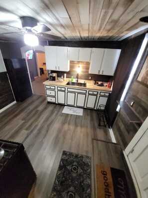A kitchen with white cabinets, a central island, and a wooden floor.